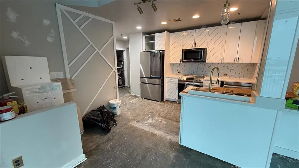 Kitchen with white cabinetry, stainless steel appliances, open shelves, tasteful backsplash, and recessed lighting