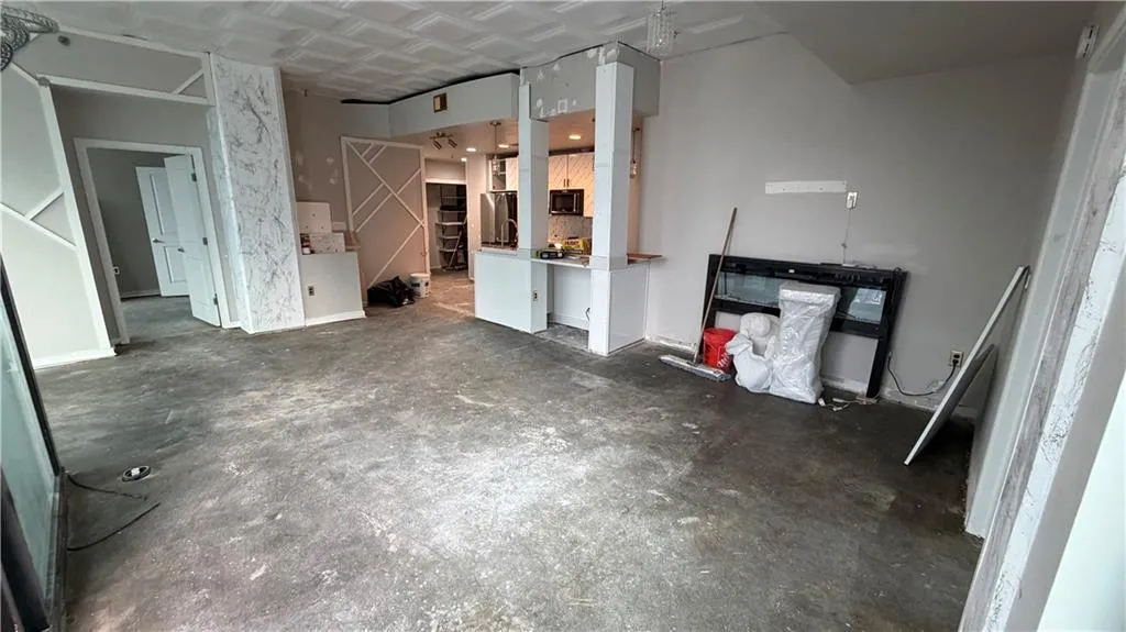 Unfurnished living room featuring concrete floors