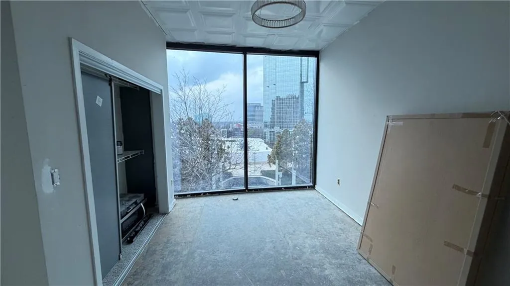 Unfurnished living room featuring floor to ceiling windows, an ornate ceiling, and a city view