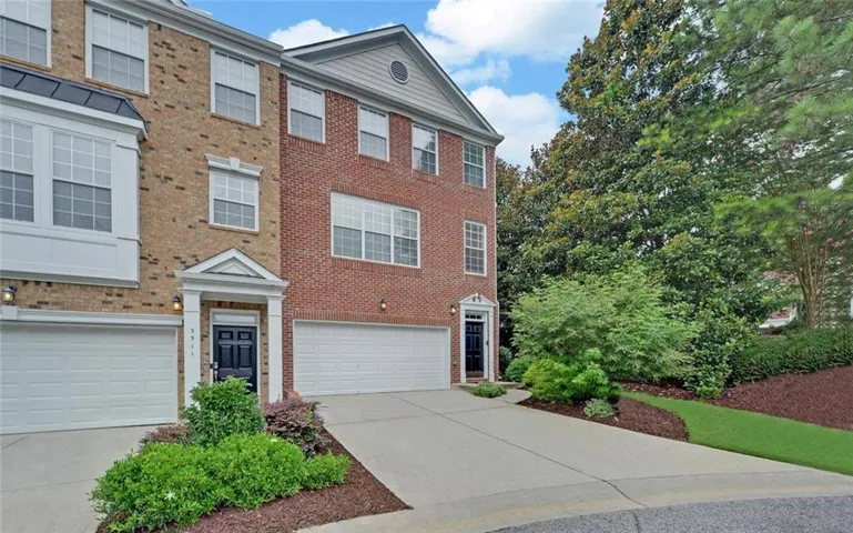 Brick exterior with multiple windows, an integrated garage, and a covered entry