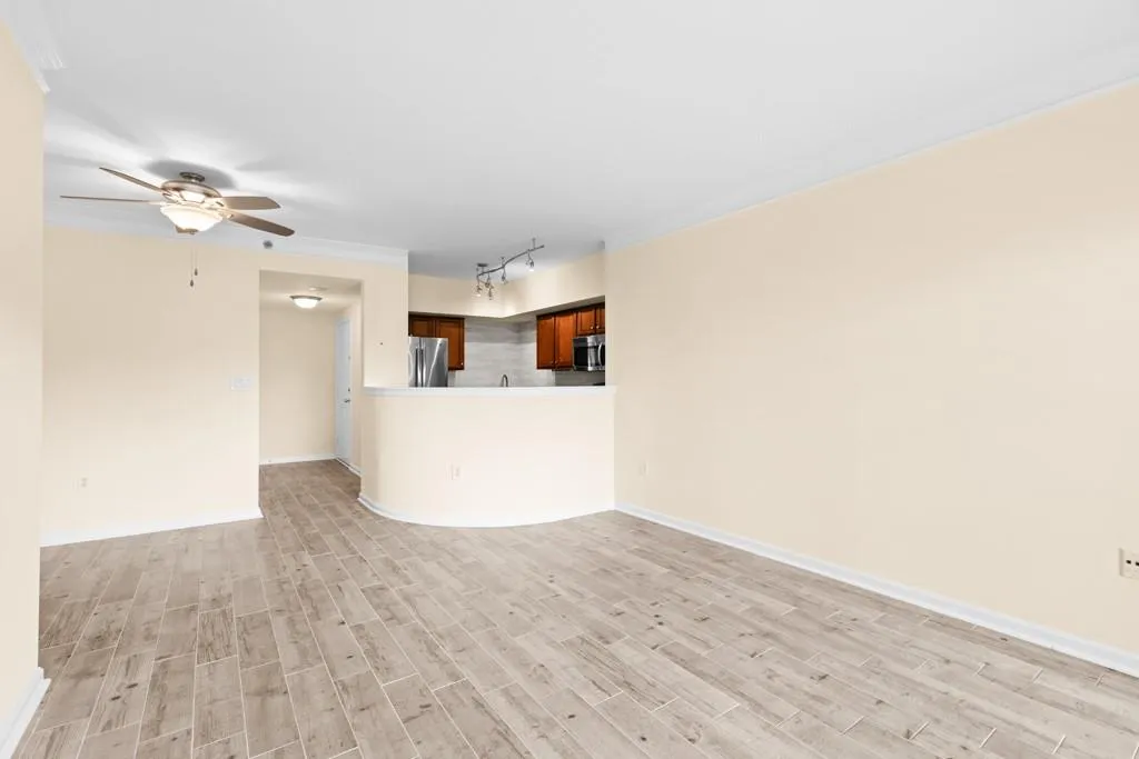 Unfurnished living room featuring a ceiling fan, baseboards, track lighting, and light wood-type flooring