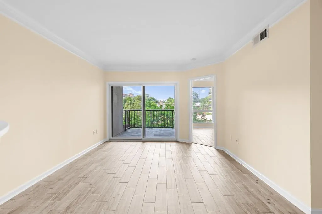 Unfurnished room with baseboards, ornamental molding, light wood-style flooring, and visible vents