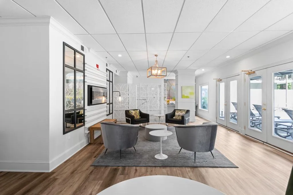 Living area featuring a healthy amount of sunlight, baseboards, crown molding, and wood finished floors