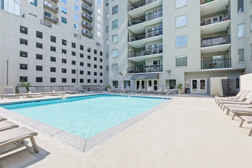 Community pool with french doors and a patio