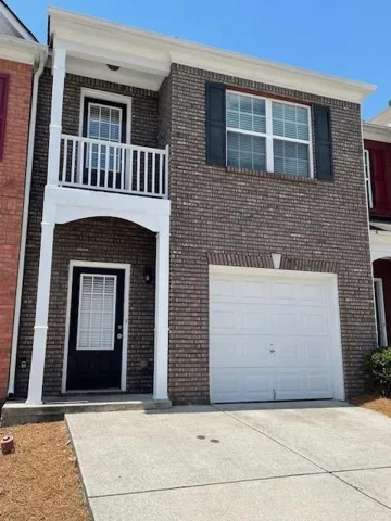 Brick exterior with white trim, featuring a single-car garage, covered entry, and upper-level balcony