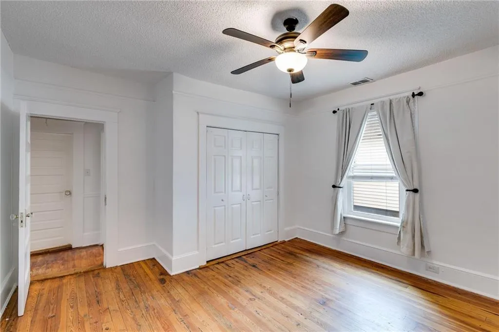 Unfurnished bedroom with light wood-style floors, a ceiling fan, a closet, and a textured ceiling