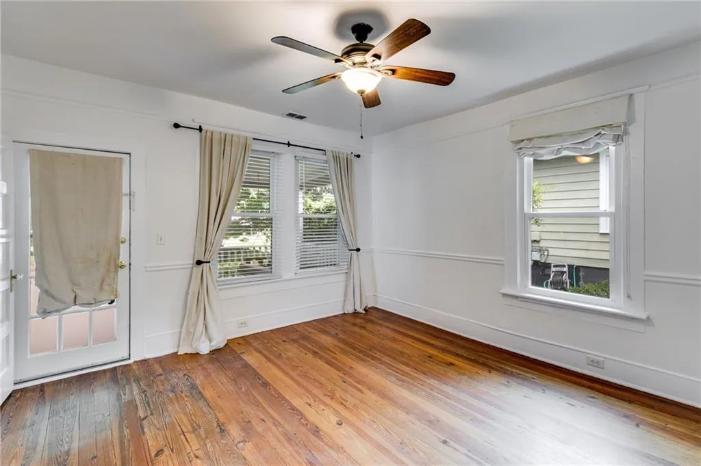 Empty room with light wood-style flooring, plenty of natural light, and ceiling fan