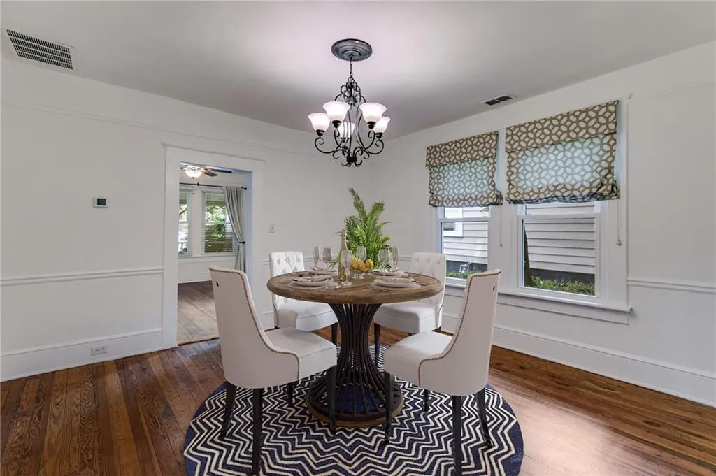 Dining area with dark wood finished floors, a chandelier, and a ceiling fan
