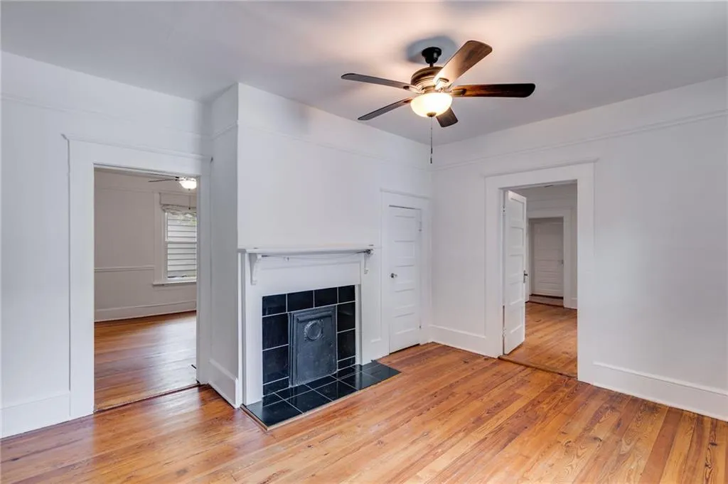 style flooring, ceiling fan, and a fireplace