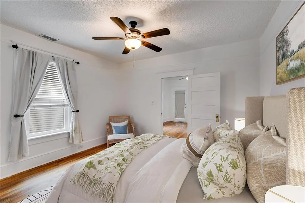 Bedroom with wood finished floors, ceiling fan, and a textured ceiling
