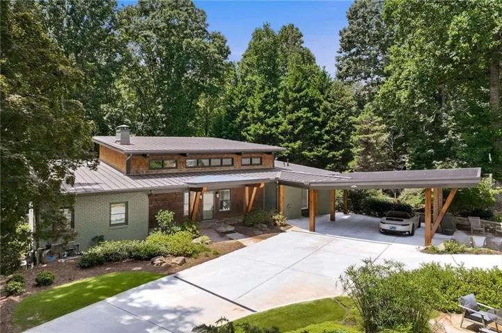 Contemporary home featuring a metal roof, wood siding accents, and a covered carport with exposed wood beams