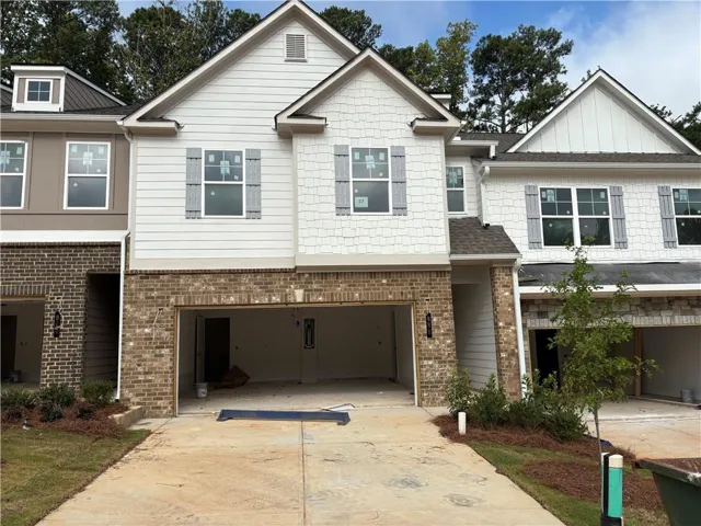 Brick and siding exterior with gabled roofline, featuring attached two-car garage