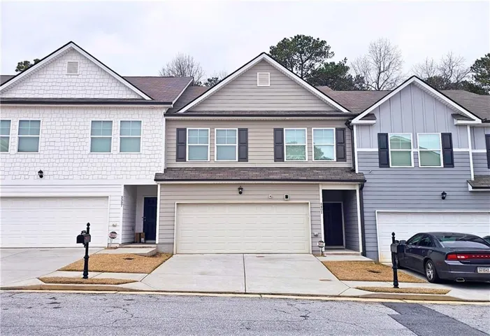 View of front of home with concrete driveway and a shingled roof