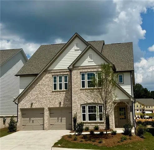 View of front of house with a shingled roof, concrete driveway, a porch, and brick siding