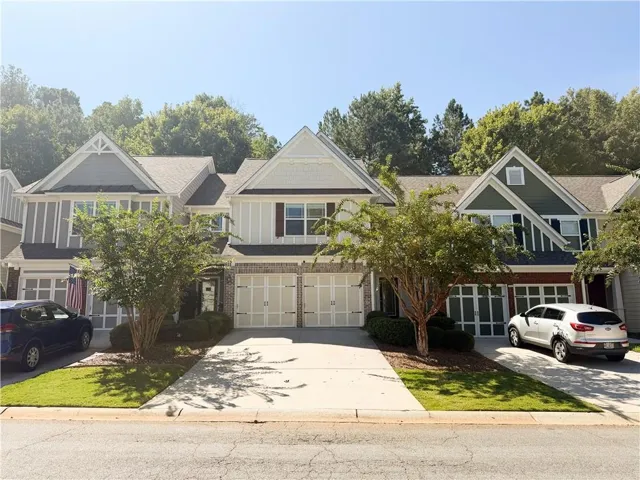 Multilevel townhome with a shingled roof and gabled dormers