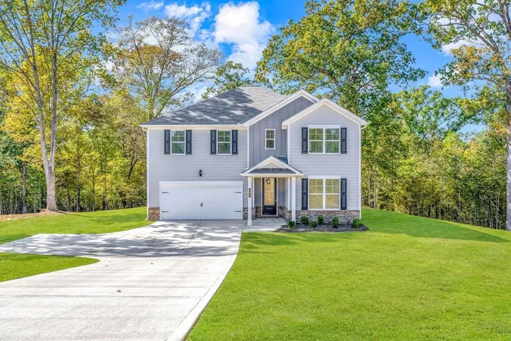 Two-story residence featuring light gray siding with dark shutters, an integrated garage, and a covered entry