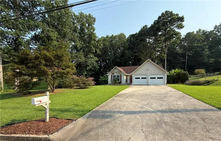 Ranch-style residence featuring a two-car garage, concrete driveway, and a stone and siding exterior