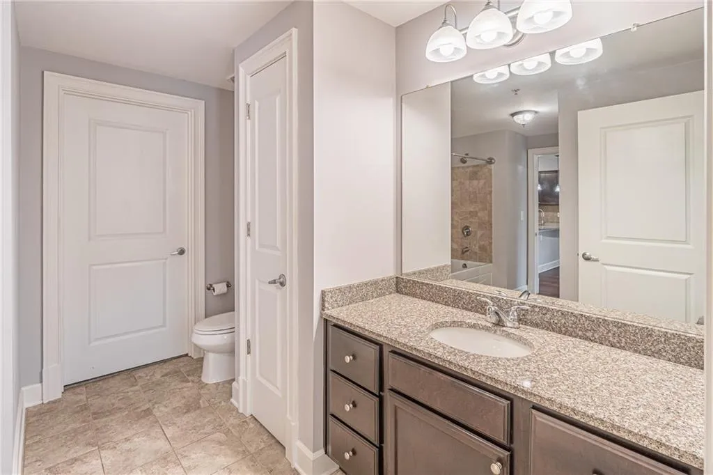 Full bathroom with toilet, vanity, and tiled shower / bath