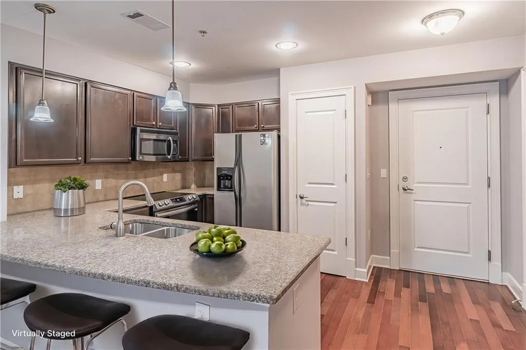 Kitchen with kitchen peninsula, pendant lighting, a breakfast bar area, and stainless steel appliances