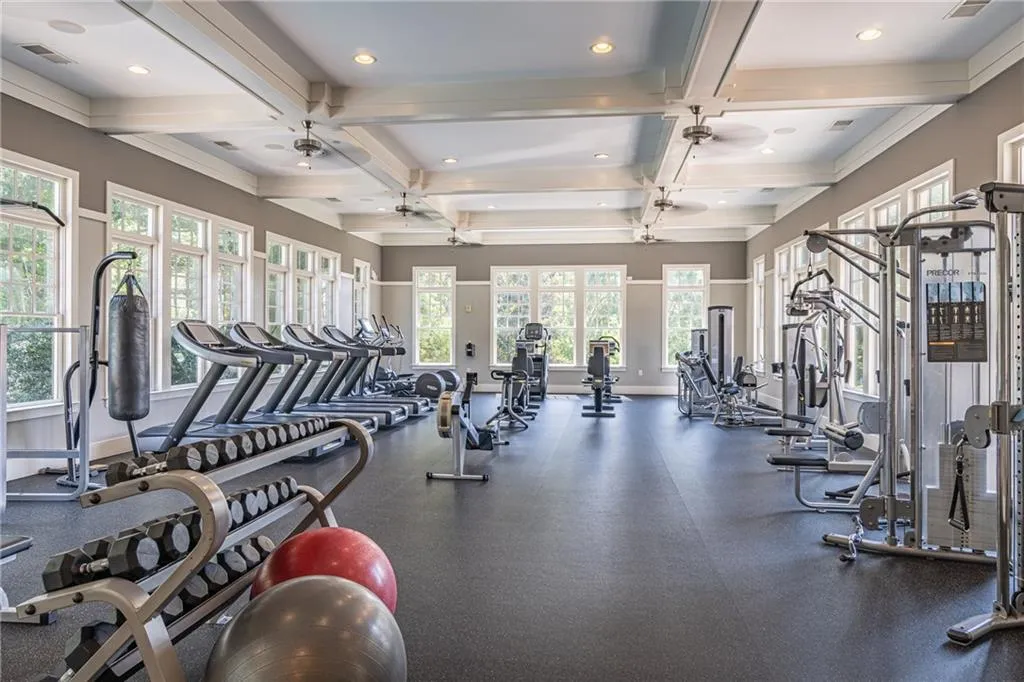 Workout area featuring coffered ceiling and ceiling fan