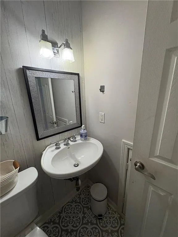 Half bathroom with wood walls and a sink