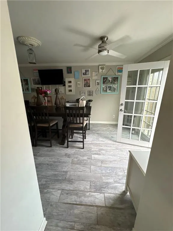 Dining room featuring light wood-style floors, ceiling fan, and ornamental molding