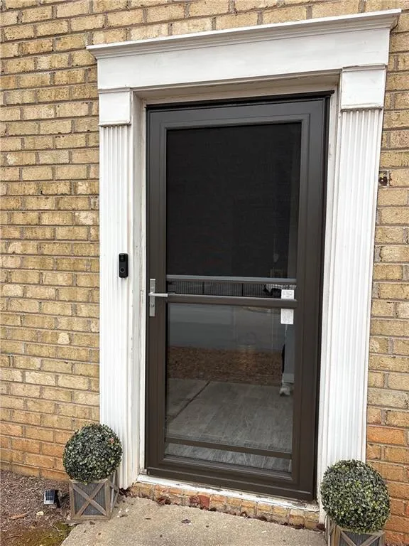 Doorway to property featuring brick siding