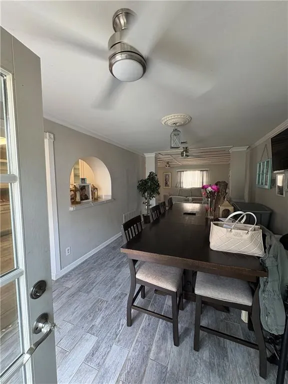Dining room with crown molding, light wood-type flooring, and a ceiling fan