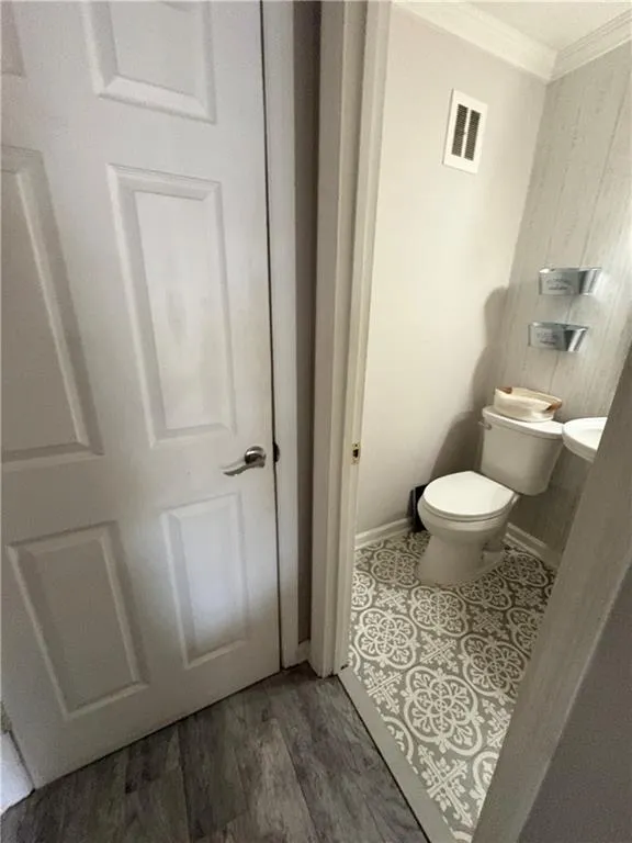 Bathroom featuring ornamental molding and light wood-style flooring