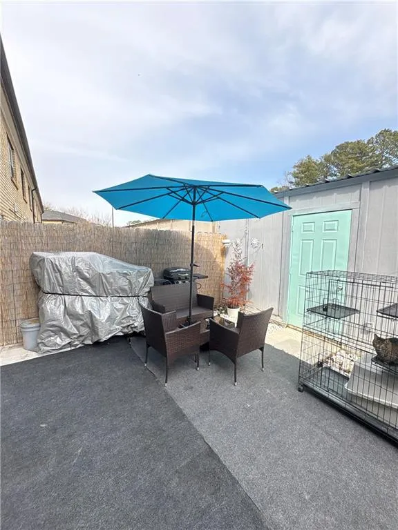 Fenced backyard with outdoor furniture, a shed, a patio area, and grilling area
