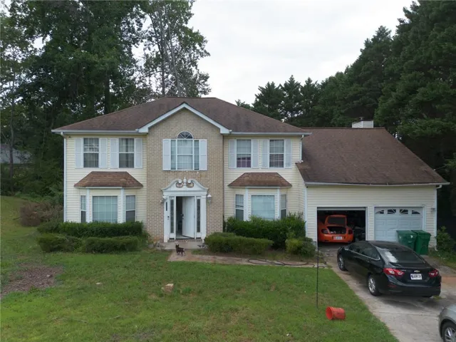 Two-story residence featuring a combination brick and siding exterior, a two-car garage, and a concrete driveway