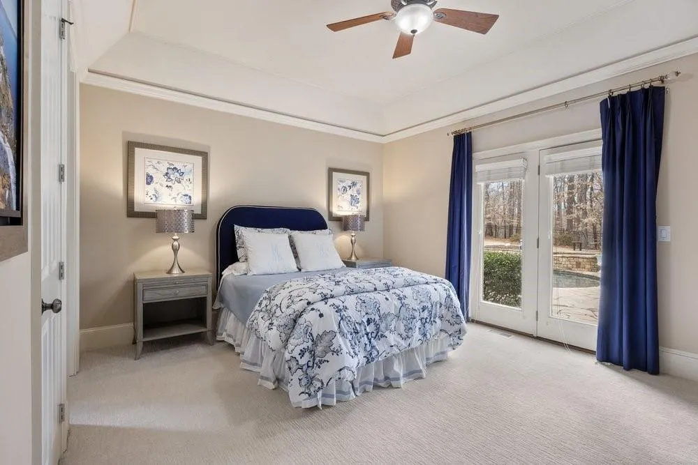 Carpeted bedroom with access to exterior, ceiling fan, a raised ceiling, and crown molding