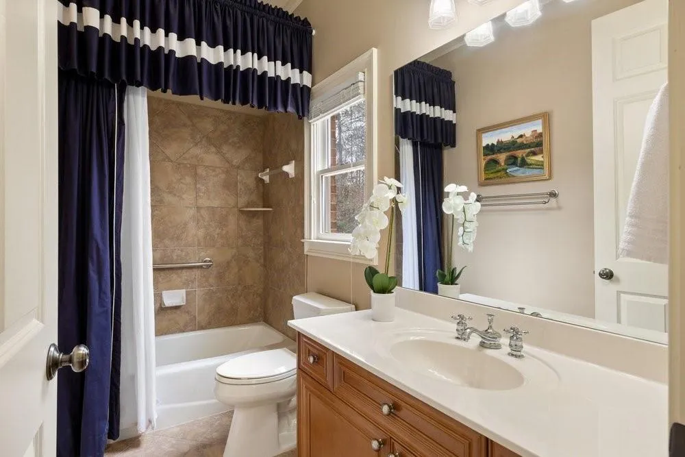 Bathroom featuring vanity, shower / bath combo, and light tile patterned floors