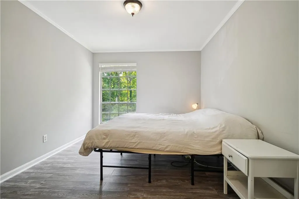 Bedroom with crown molding and dark hardwood / wood-style floors