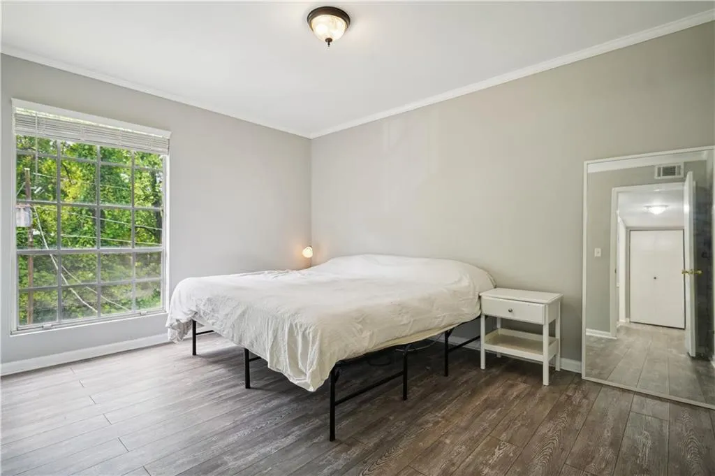 Bedroom featuring ornamental molding and wood-type flooring