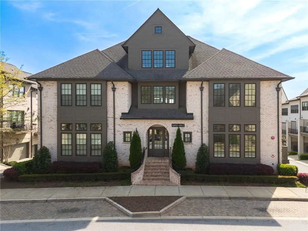 French country style house featuring brick siding and a shingled roof