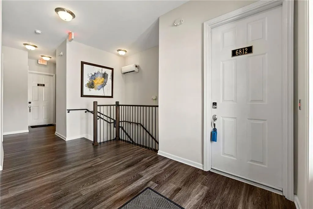 Foyer with an AC wall unit, baseboards, and dark wood-type flooring
