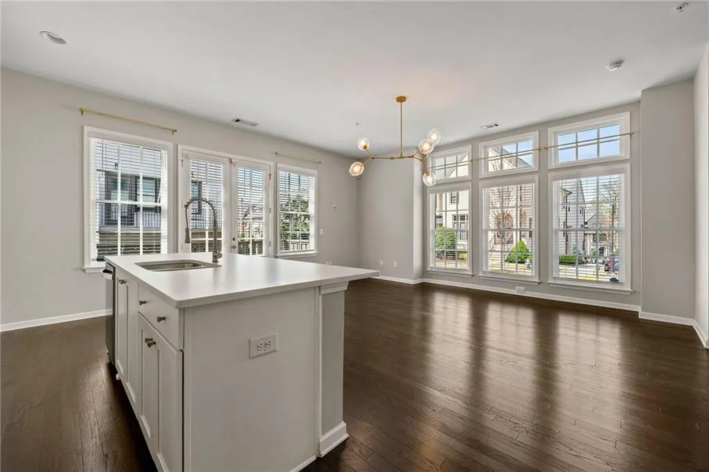 Kitchen featuring light countertops, a sink, plenty of natural light, and dark wood finished floors