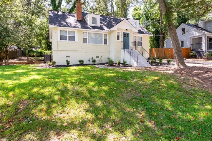 Cream-colored exterior with a dormer window and brick chimney