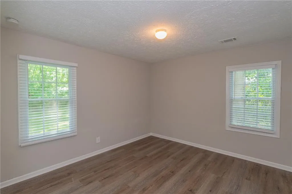Kitchen with stainless steel appliances, light countertops, ceiling fan, white cabinets, and light wood-style floors