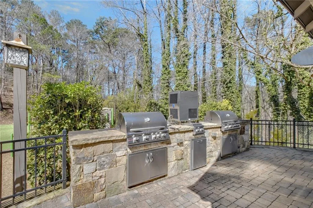 View of patio featuring area for grilling and view of wooded area