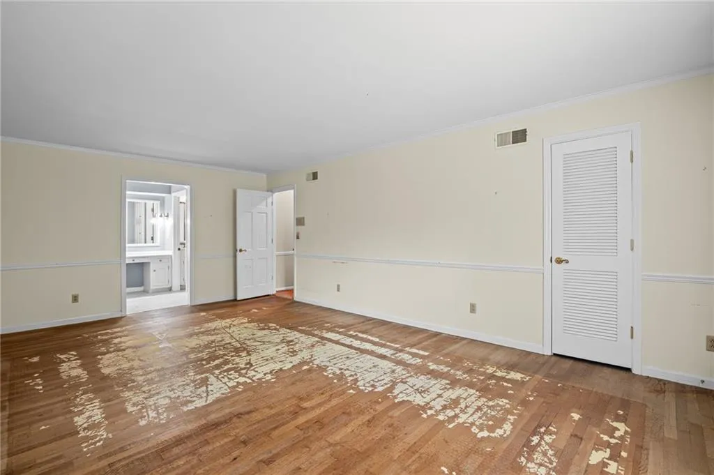 Unfurnished living room featuring hardwood / wood-style flooring and ornamental molding