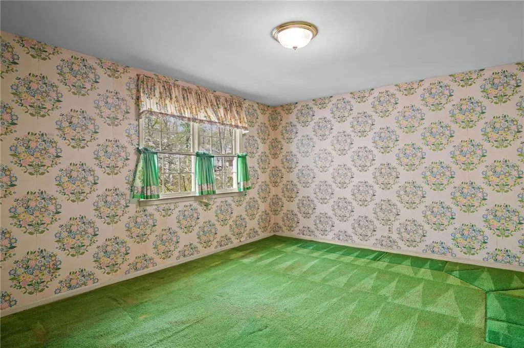 Spare room featuring wallpapered walls and carpet floors