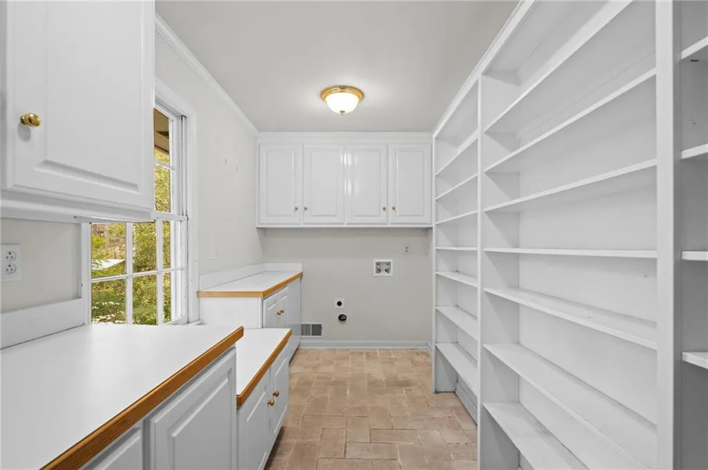 Laundry room with hookup for a washing machine, cabinet space, hookup for an electric dryer, and crown molding
