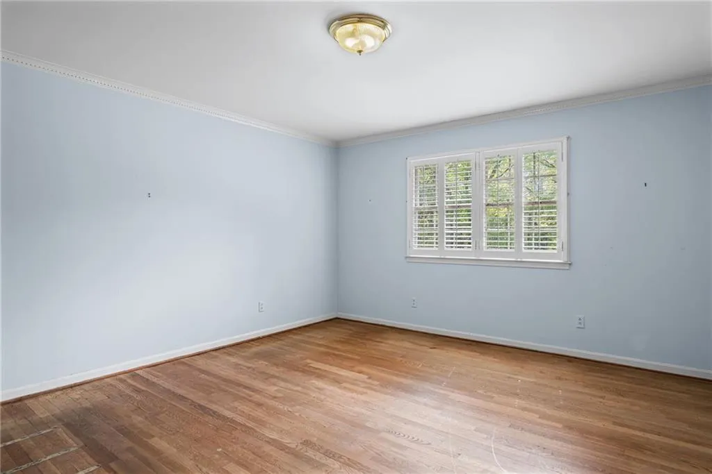 Unfurnished room featuring light wood-type flooring and crown molding