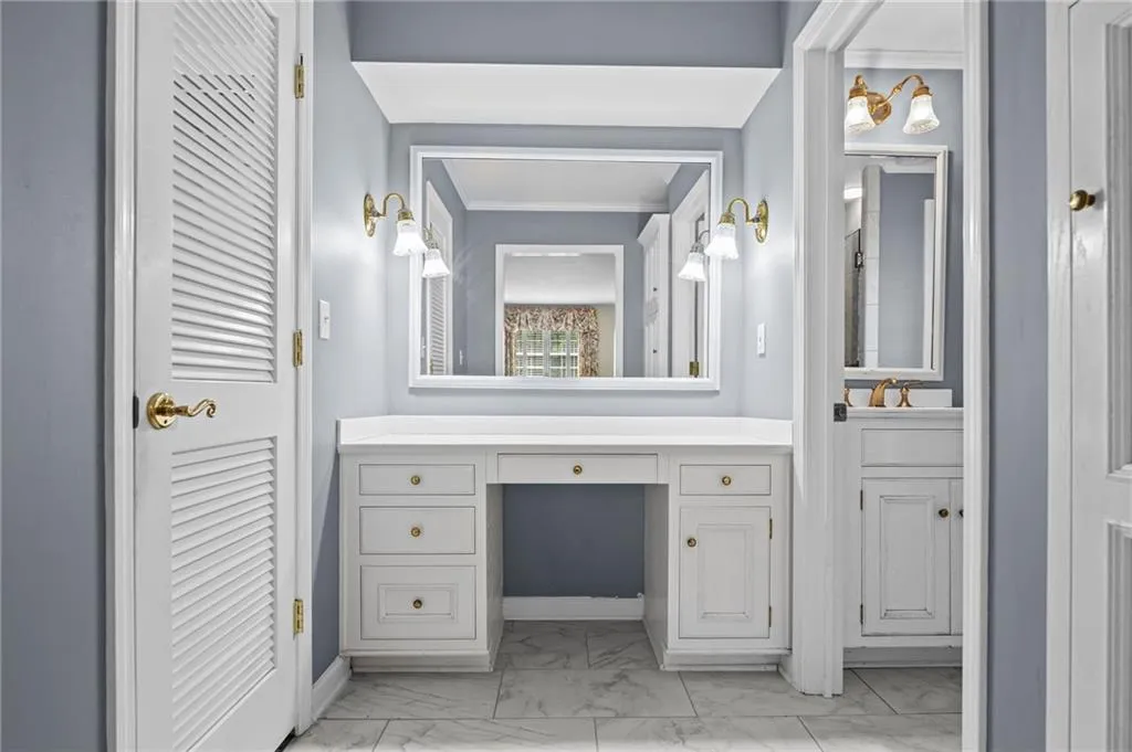 Bathroom featuring vanity and light marble finish flooring