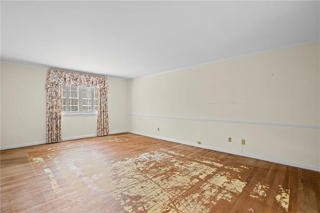 Unfurnished room featuring wood finished floors and ornamental molding