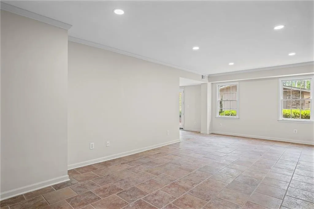 Spare room with crown molding, recessed lighting, and light stone finish flooring