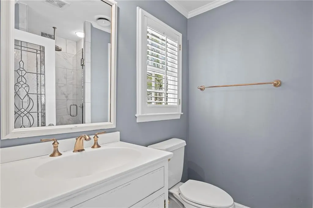 Bathroom with vanity, a stall shower, and ornamental molding