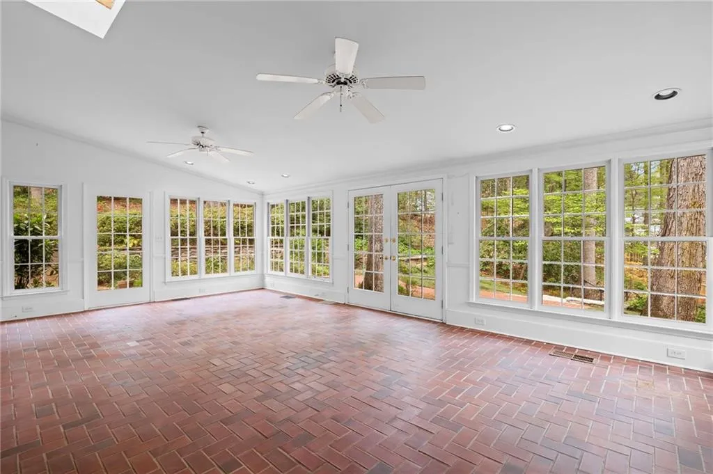 Unfurnished sunroom with french doors, healthy amount of natural light, a skylight, recessed lighting, and lofted ceiling
